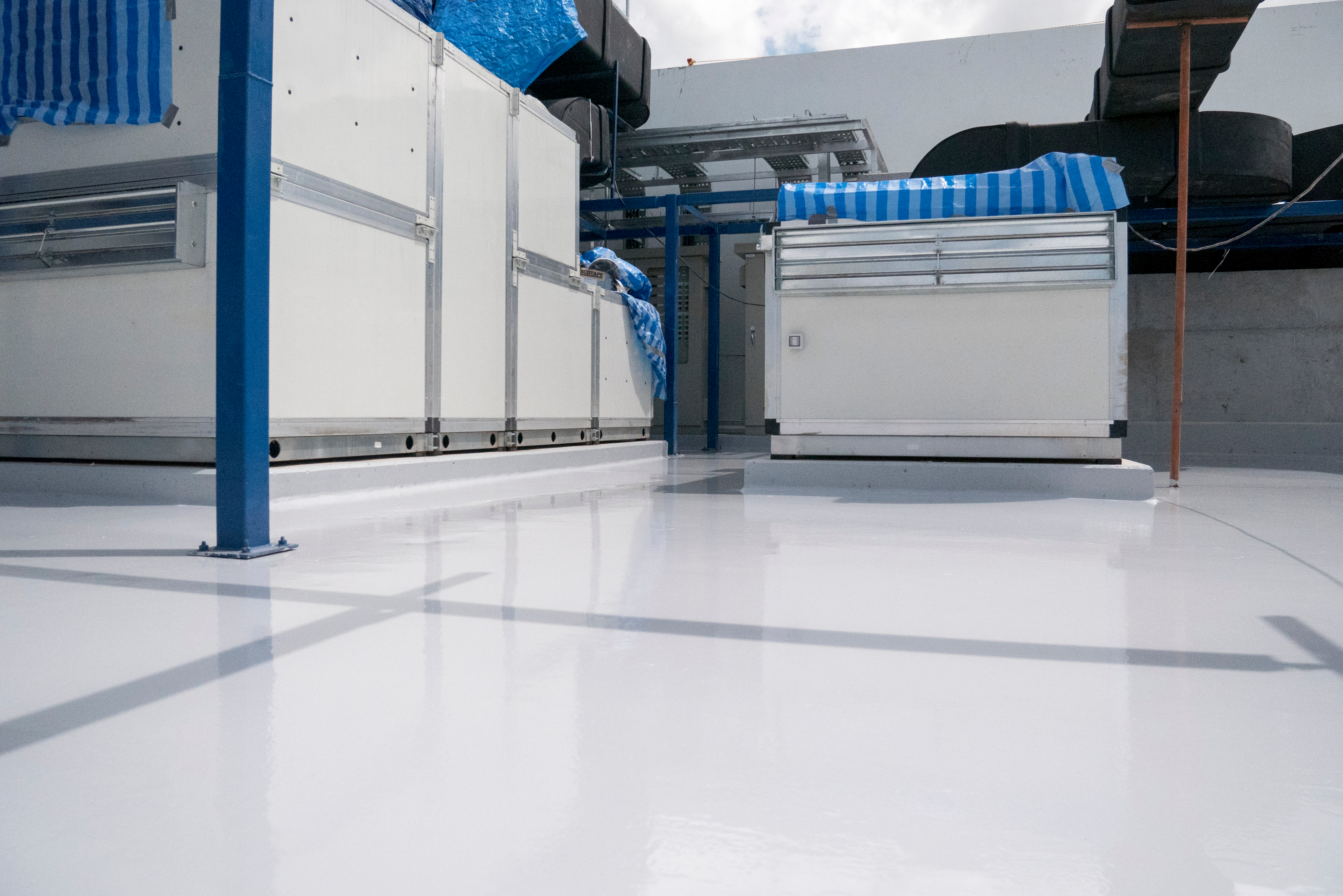 Smooth light-gray epoxy floor around mechanical equipment